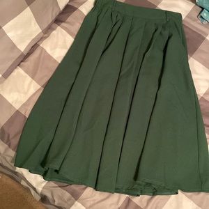 Polyester forest green skirt with pockets, size XS.